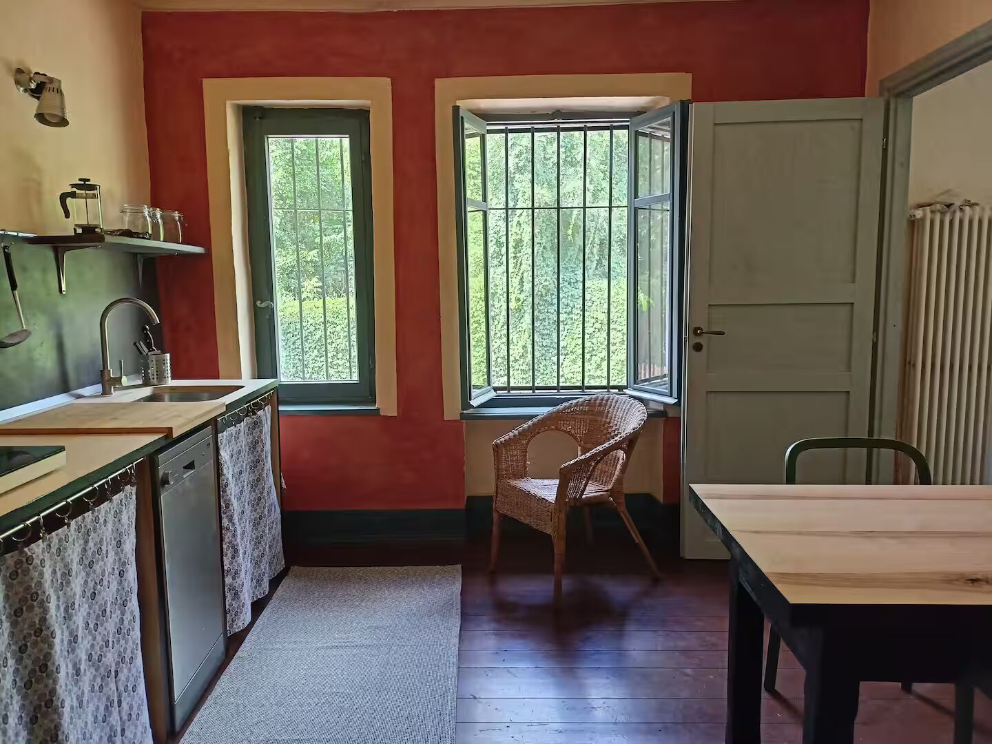 Cucina con pareti rosse e finestre sul giardino